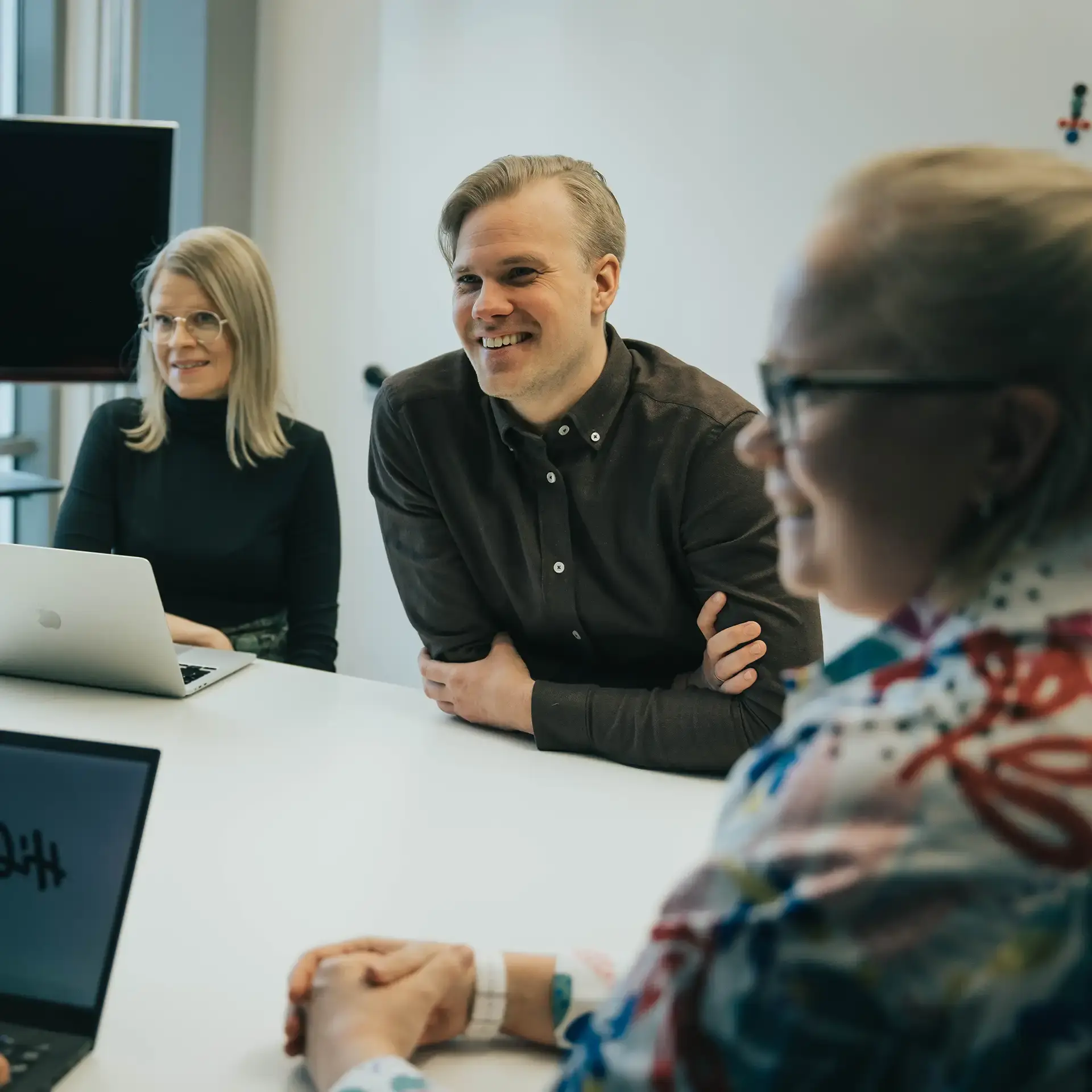 Employees smiling while sat around a table