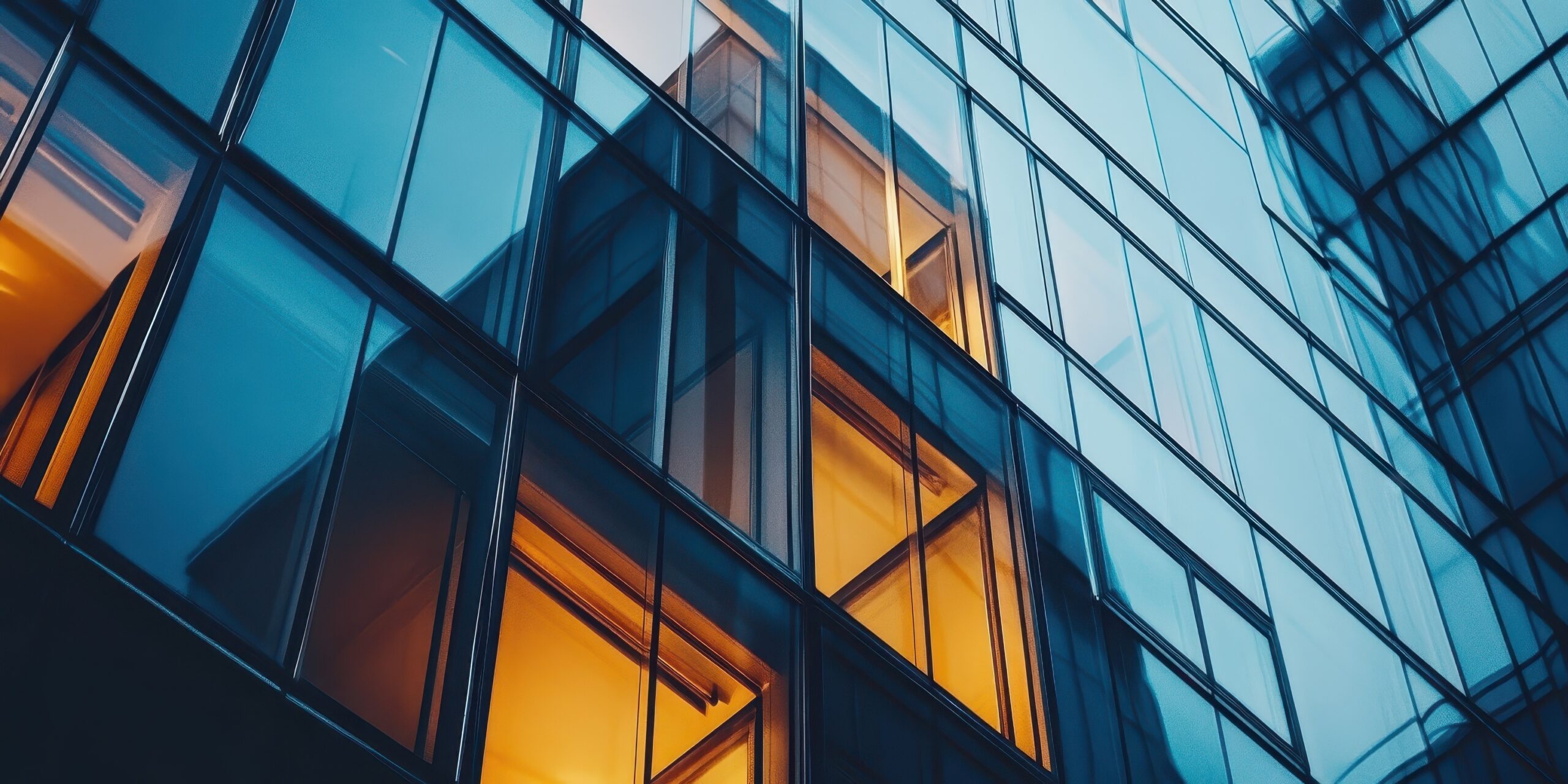 A building with many windows and a yellow light shining through one of them